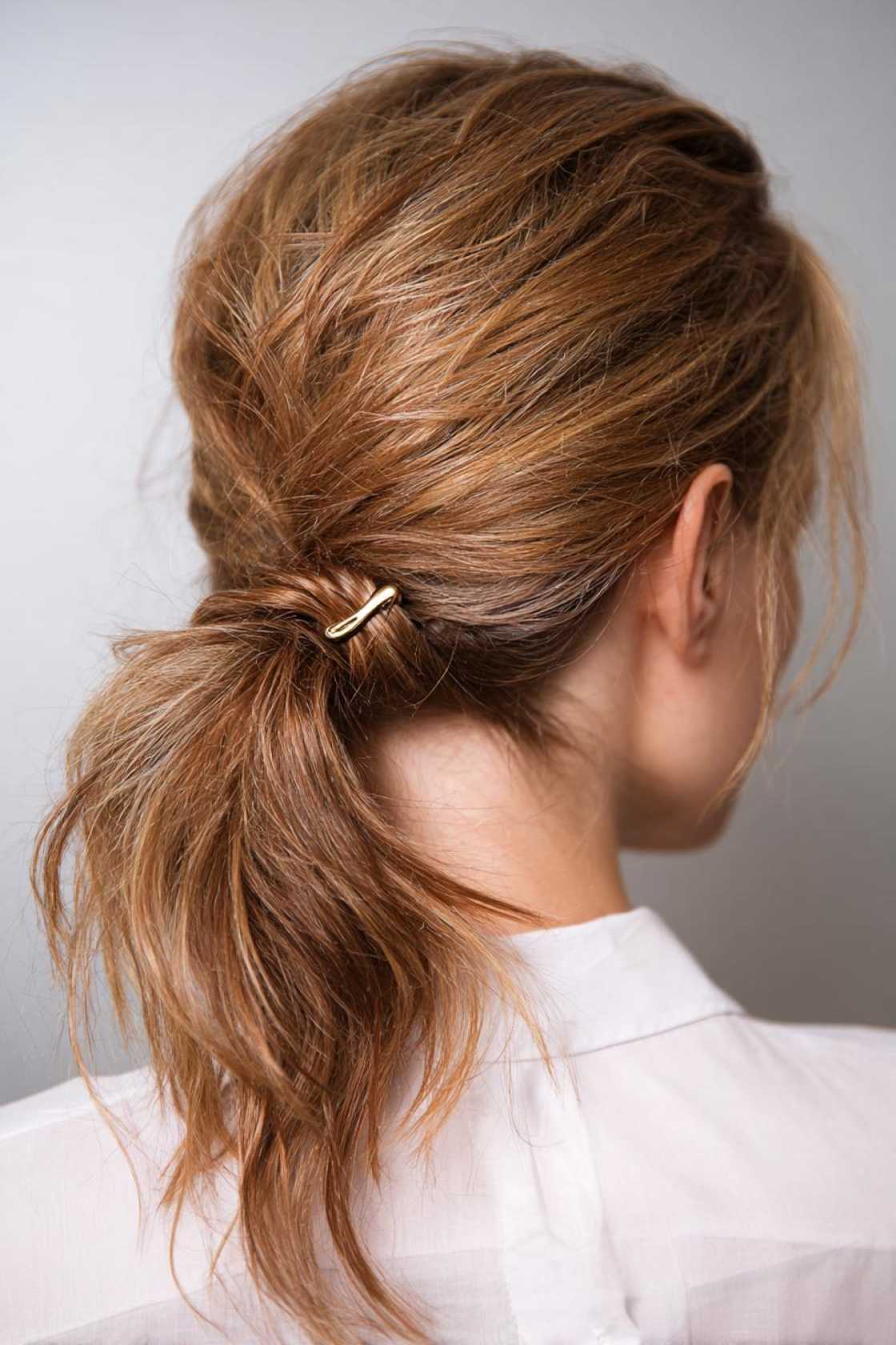 23+ Effortless Messy Claw Clip Hairstyles (Quick Twists & Buns!) - 17. Textured Low Ponytail